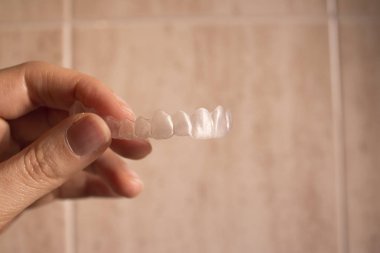 Bir kadın el ile düzenlenen görünmez diş diş telleri