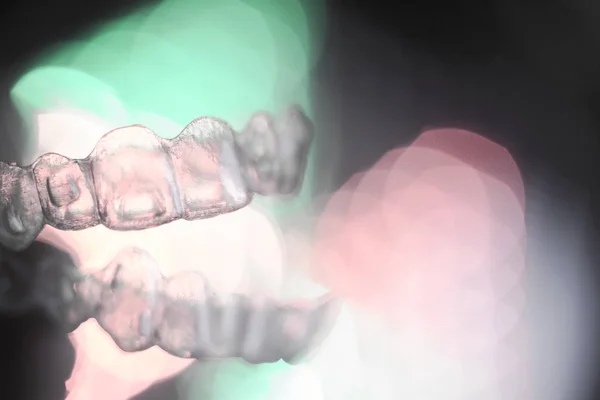 Unsichtbare zahnärztliche Kieferorthopädie auf farbigem Hintergrund — Stockfoto