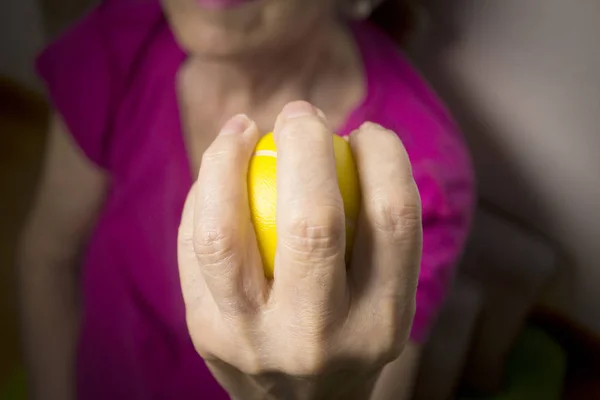 Mulher sênior fazendo exercícios com uma bola nas mãos — Fotografia de Stock