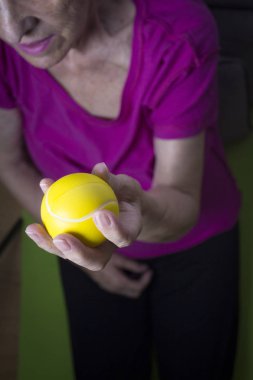 Ellerini bir top ile egzersizleri yapıyor kadın kıdemli