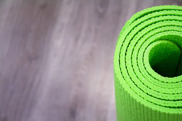 Yoga mat on wooden floor