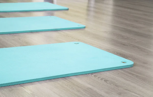 Yoga mat on wooden floor — Stock Photo, Image