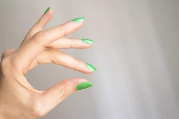 Mulher mão com unhas pintadas de verde — Fotografia de Stock