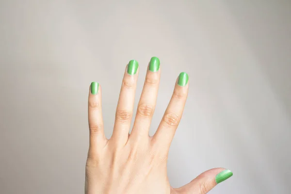 Mulher mão com unhas pintadas de verde — Fotografia de Stock