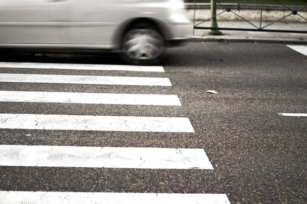 Pedestrian crossing with unfocused car in the background — Stock Photo, Image
