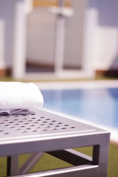 Asciugamano sul tavolo nella piscina di un hotel di lusso — Foto Stock