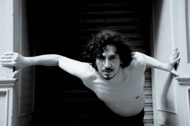 Latin erkek dansçı dans figürleri ile poz. Kentsel arka plan