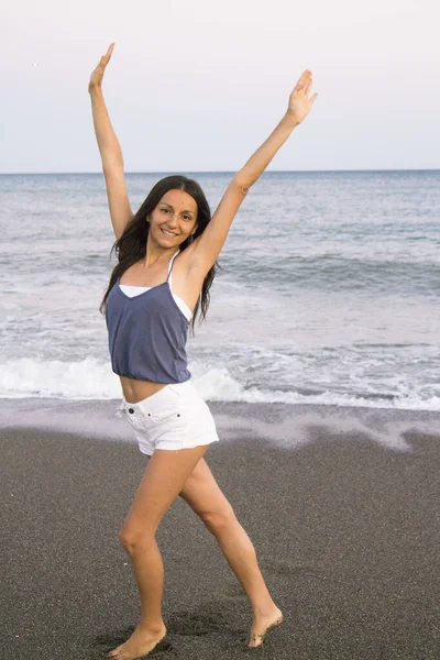 해변의 젊은 여자는 매우 긍정적 이고 행복 한 태도를 나타낸다 — 스톡 사진