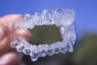 Kadın eli tarafından tutulan görünmez diş telleri