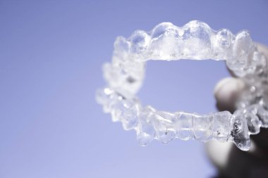 Kadın eli tarafından tutulan görünmez diş telleri