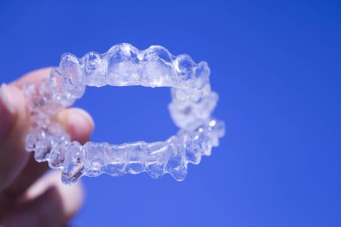 Kadın eli tarafından tutulan görünmez diş telleri