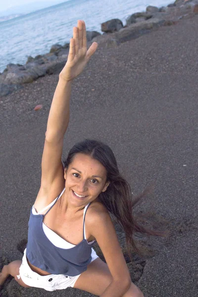 Jovem atleta praticando ioga na praia — Fotografia de Stock