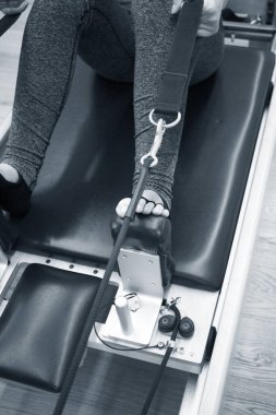 Kadın pilates makinesi egzersizleri yapıyor.