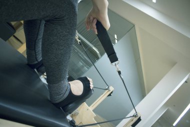 Kadın pilates makinesi egzersizleri yapıyor.