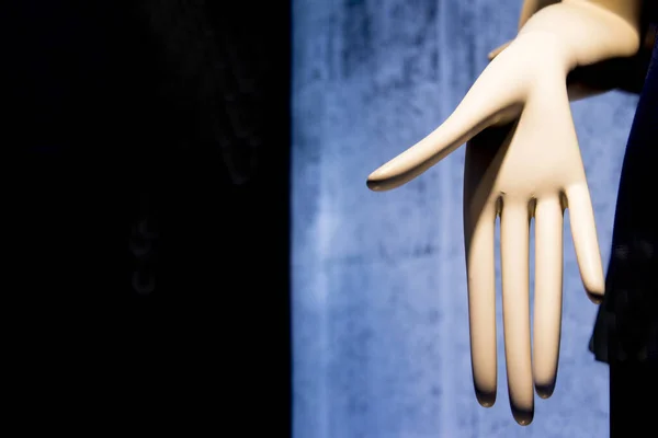 Artificial hand showing palm of hand on dark background. No people