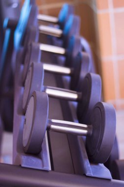 Spor salonunda siyah halterler. Kimse yok.