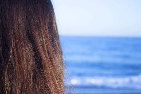 Sırtında kadın başıyla sahili görmek. Kahverengi saçlı