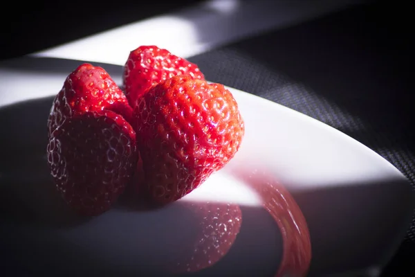 접시와 어두운 배경에 딸기를 얹는다 사람도 — 스톡 사진