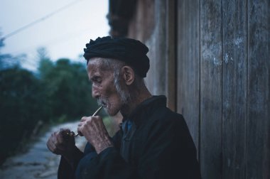 Guilin, Çin - 15 Haziran 2015: piposunu Çin yaşlı aydınlatan bir kadeh.