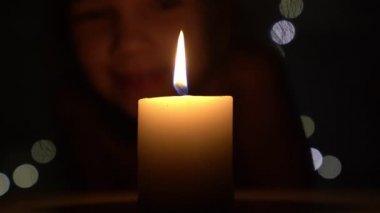 Karanlıkta mum ve küçük kız.