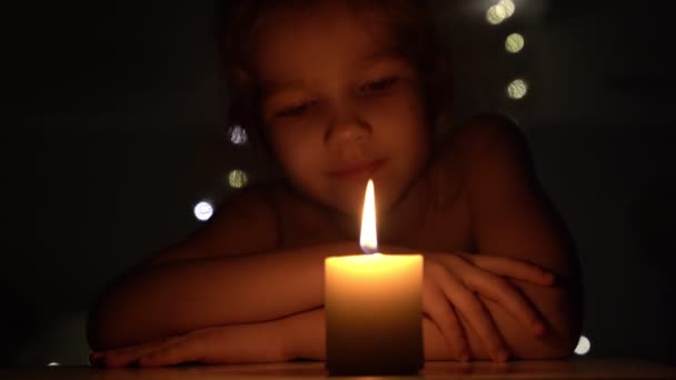Svíčka ve tmě a malá holčička. — Stock video