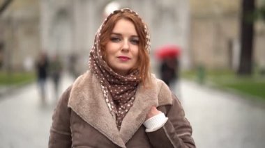 Beautiful girl on the street in the rain in scarf