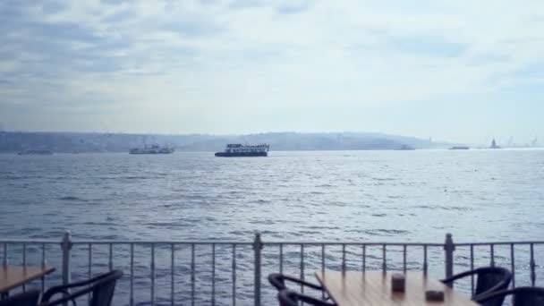 The cafe tables near the sea with ships and waves — Stok video