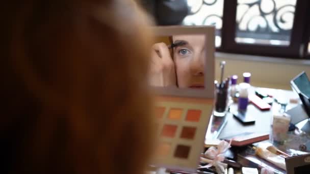 The girl looks in the mirror and color eyebrows — Stok video