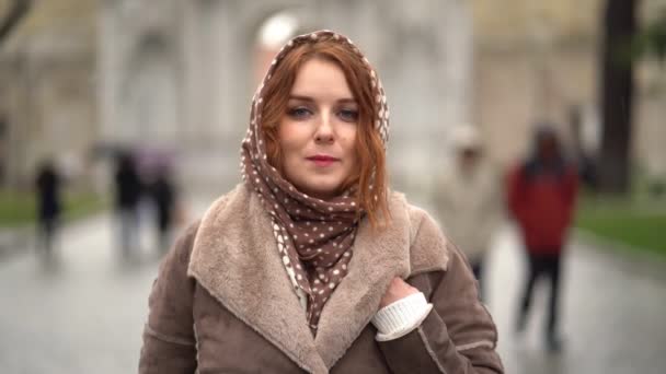Menina ruiva bonita em um lenço de cabeça na chuva tímido — Vídeo de Stock