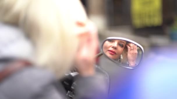 La bionda si guarda allo specchio su un motorino — Video Stock