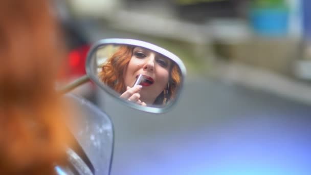 La chica con el lápiz labial de pelo rojo en el espejo — Vídeos de Stock