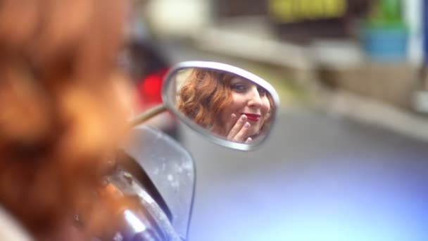 Ruiva menina olha no espelho em um ciclomotor — Vídeo de Stock