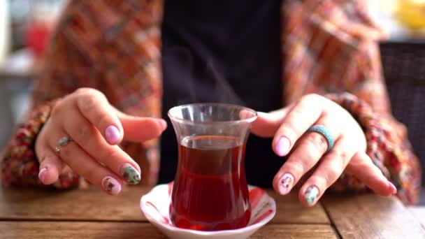 Szőke egy kávézóban, forró teát iszik. — Stock videók