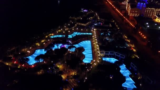 Vista notturna dell'hotel con piscine e luci — Video Stock