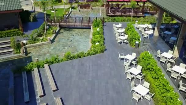 Вид сверху на бассейны с солнцезащитными креслами и зонтиками — стоковое видео