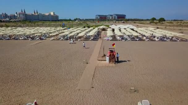 Playa de arena con sombrillas blancas — Vídeos de Stock