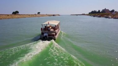The boat sails through the canal and carries people to the beach