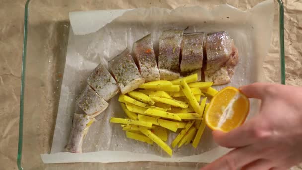 Cooking. Fish and potatoes on pan, put lemon — Αρχείο Βίντεο