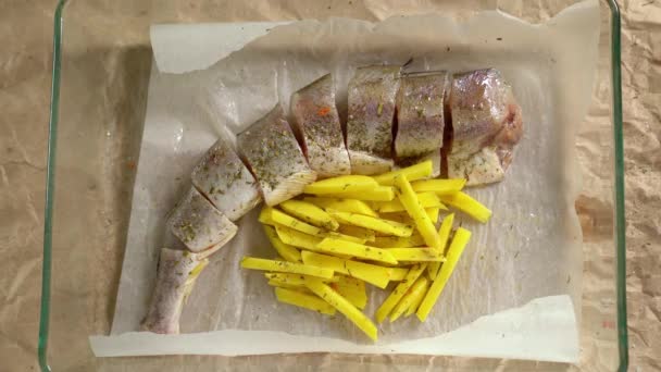 Cozinhar. Peixe e batatas pan temperos polvilhados — Vídeo de Stock