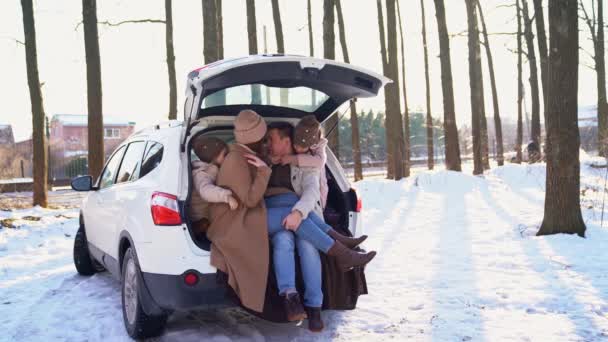 Family with daughters sitting in the trunk of car — Αρχείο Βίντεο