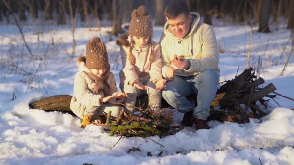 Family roast on the campfire weenies in the winter — Stock Video