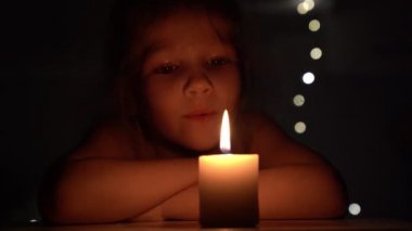 Karanlıkta mum ve küçük kız.