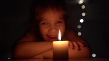 Karanlıkta mum ve küçük kız.