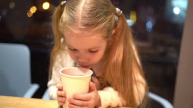 Küçük sarışın, kuyruklu, akşamları kafede sıcak çay içen kız..