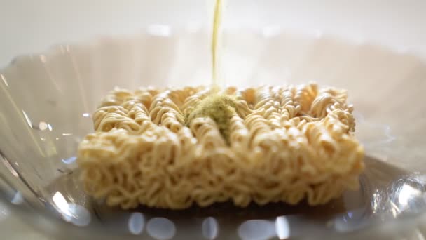 On the noodles, pour the seasoning, close-up side view. — Stockvideo