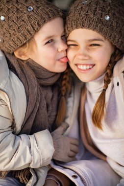 Two sisters playing in the car in the winter