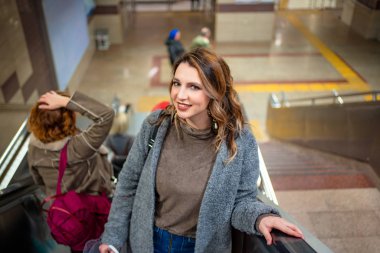 Uzun saçlı güzel kız yağmurdan sonra metroya iniyor.