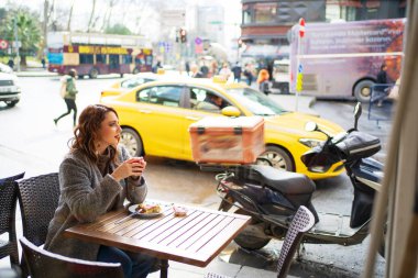 Kafede sıcak çay içen bir kız.