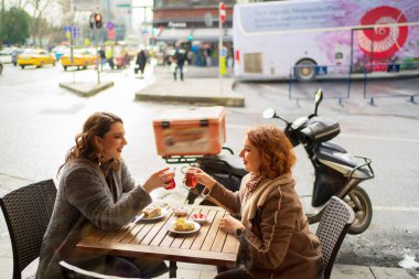 Bir kafede oturup çay içen iki kız arkadaş.