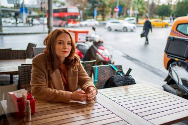 Kafede elinde telefon olan bir kız.